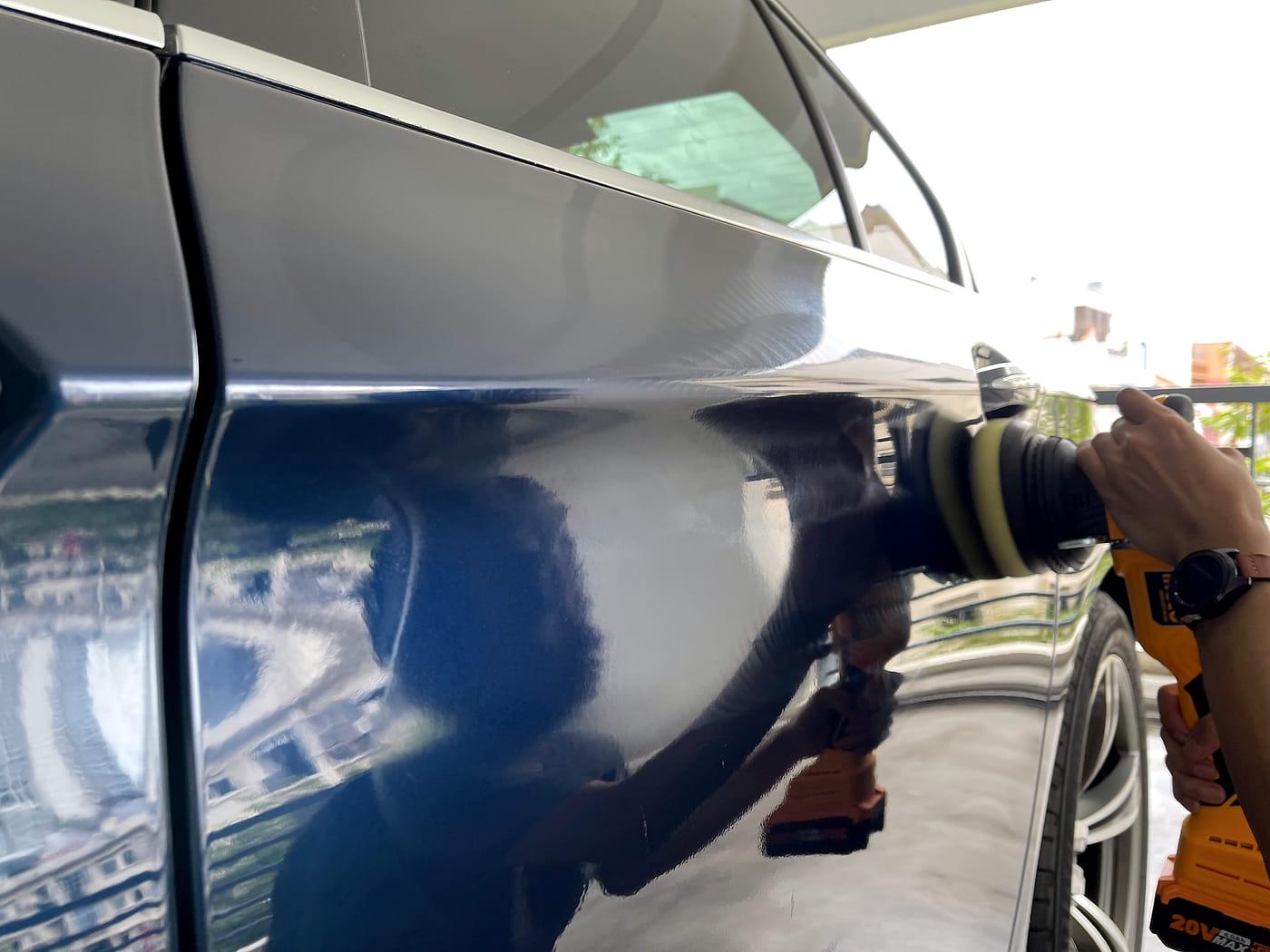 A PA detailer machine polishing a dark car door