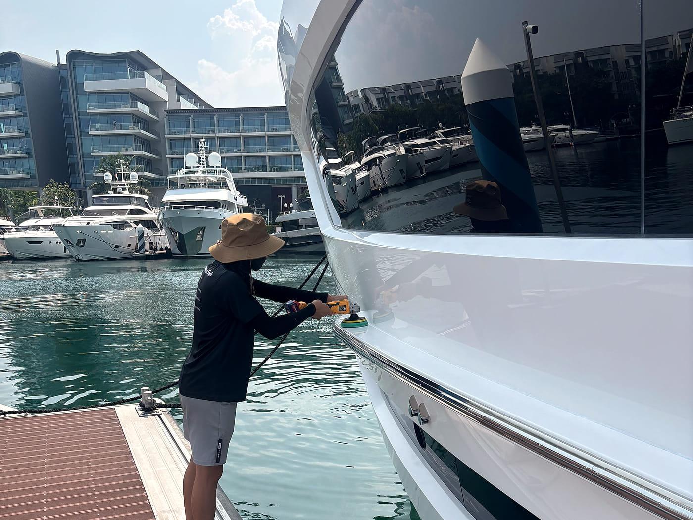 A PA detailer polishing a yacht at the berth